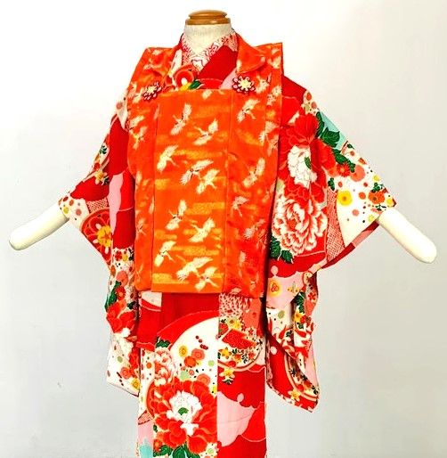 Red children's kimono with peonies and an orange crane-pattern hifu vest